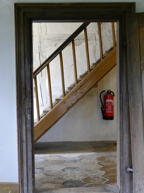Das Motiv zeigt den Blcik durch die Türe in ein historisches Treppenhaus.