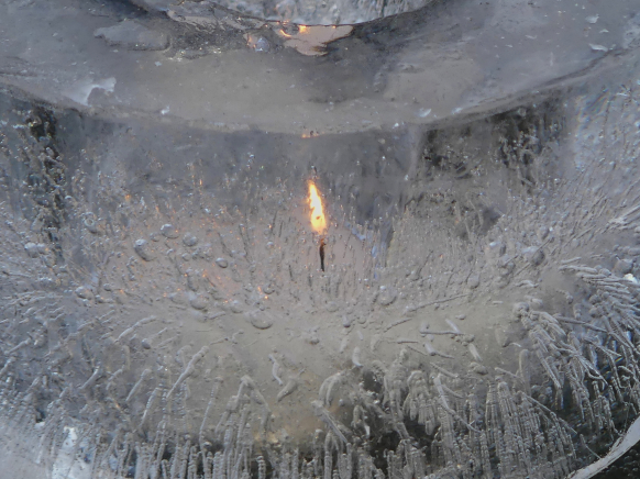 Bild des Monats, Januar 2026 - ein Eiswindlicht mit brennender Kerze
